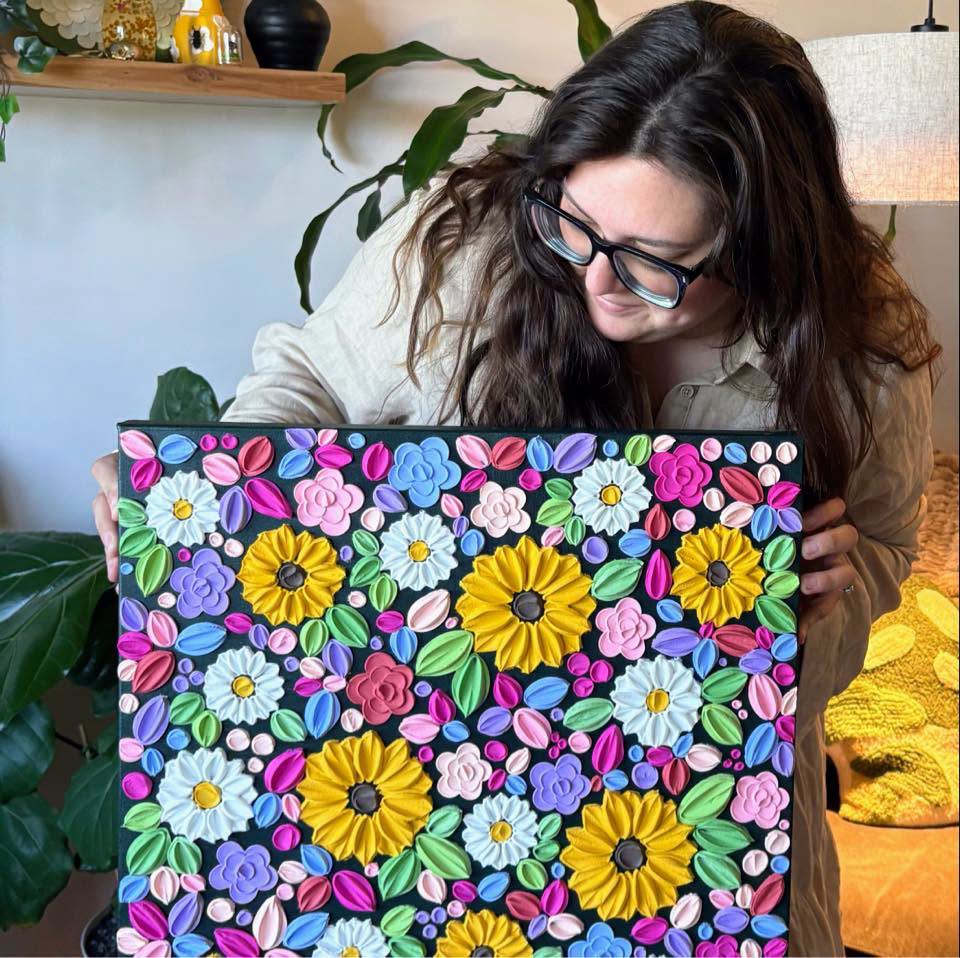 Women artist holding a textured painting