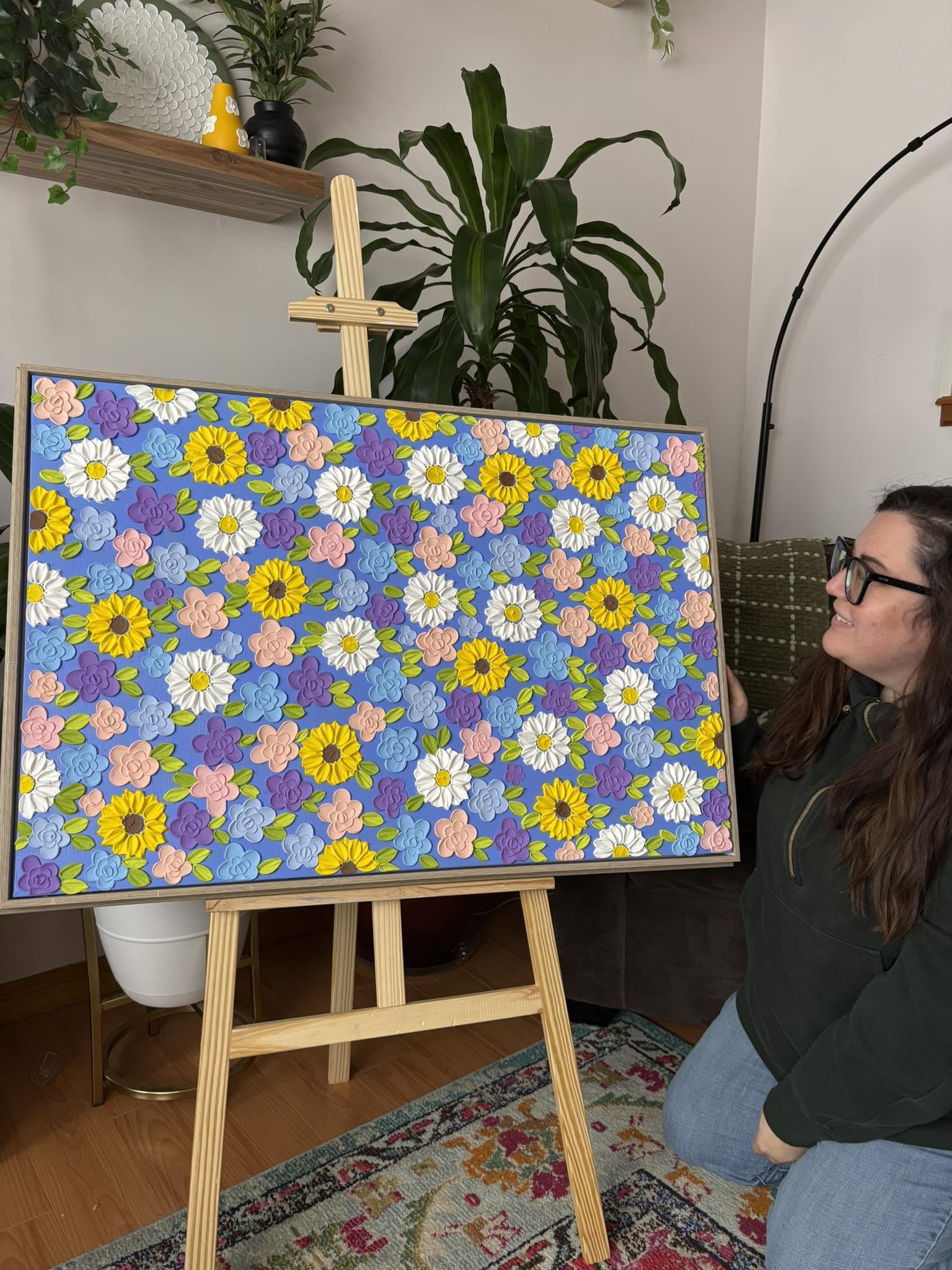 the artist looking at blue flowered art piece